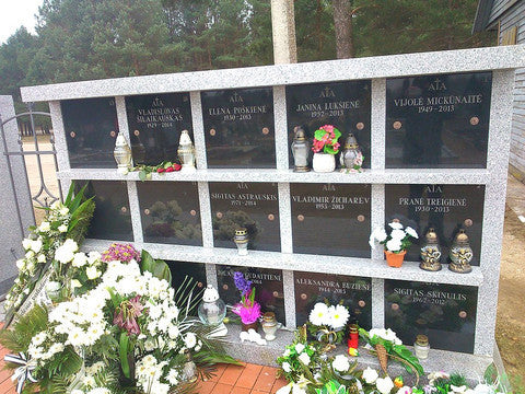 Jonava cemetery columbarium with flowers in front and urns in niches.