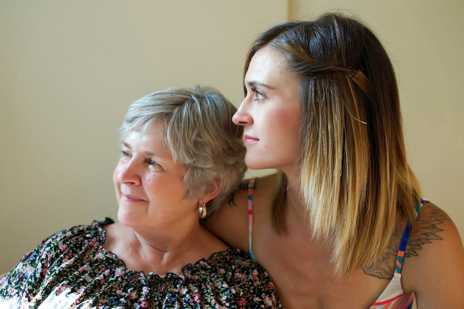 Two women of two different generations smiling while hugging.