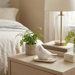 Pearl songbird cremation keepsake in a home decor setting on a nightstand.