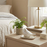 Pearl songbird cremation keepsake in a home decor setting on a nightstand.