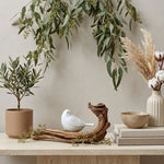 Pearl songbird cremation keepsake in a home decor setting on a table.