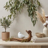 Pearl songbird cremation keepsake in a home decor setting on a table.