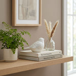 Pearl songbird cremation keepsake in a home decor setting on a shelf.