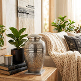 Traditional Brass Cremation Urn with a polished pewter finish featuring an etched leaf design in a home decor setting.