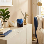 Sky blue heart cremation urn with stand in a home decor setting.