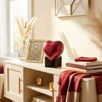 Ruby red brass heart keepsake with heart stand in a home decor setting.
