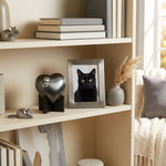 Metal heart cat urn keepsake in a slate finish with silver paw prints displayed on a heart stand in a home decor setting.