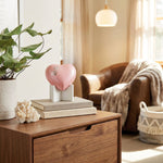 Pearl pink metal heart pet urn featuring two pewter paw prints in a home decor setting.