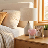 Pink heart cat urn with two silver paw prints in a home decor setting.