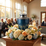Aluminum cremation urn with pewter-plated brass lid and base featuring a glossy indigo finish and floral pewter band in a funeral service setting.