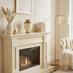 Traditional cremation urn featuring a shimmery pearl white finish, gold accents, and a floral band in a home decor setting above a fireplace.