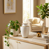 Brass cremation urn with a shimmery pearl finish and bronze accents in a home decor setting.