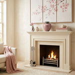 Eastern style brass cremation urn in a pink finish with a pewter lid on a mantle above a fireplace.