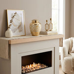 Metal cremation urn with mother of pearl inlay in a home decor setting above a fireplace.
