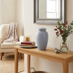 Elegant metal greyish white cremation urn in a home decor setting.