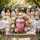 Metal cremation urn in vibrant pink finish with pewter floral band in a celebration of life setting.