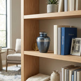 Medium metallic blue banded cremation urn in a home decor setting on a bookshelf.