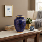 Vibrant blue cloisonne urn featuring a delicate floral motif with gold accents in a bright home decor setting.