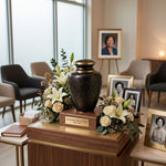 Stunning Black, grey, and onyx cloisonne cremation urn featuring a floral motif with gold accents in a funeral service setting.