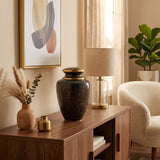 Stunning Black, grey, and onyx cloisonne cremation urn featuring a floral motif with gold accents in a warm, modern home decor setting.