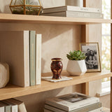 Brown butterfly cloisonne cremation keepsake with gold accents in a home decor setting on a bookshelf. 