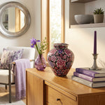 Pink and purple metal filigree cloisonne urn with a floral design in a home decor setting.
