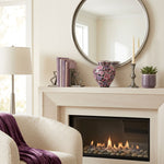 Pink and purple metal filigree cloisonne urn with a floral design in a home decor setting above a fireplace.
