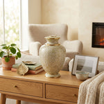 Elegant cream and beige floral cloisonne urn in a home decor setting on a cabinet.