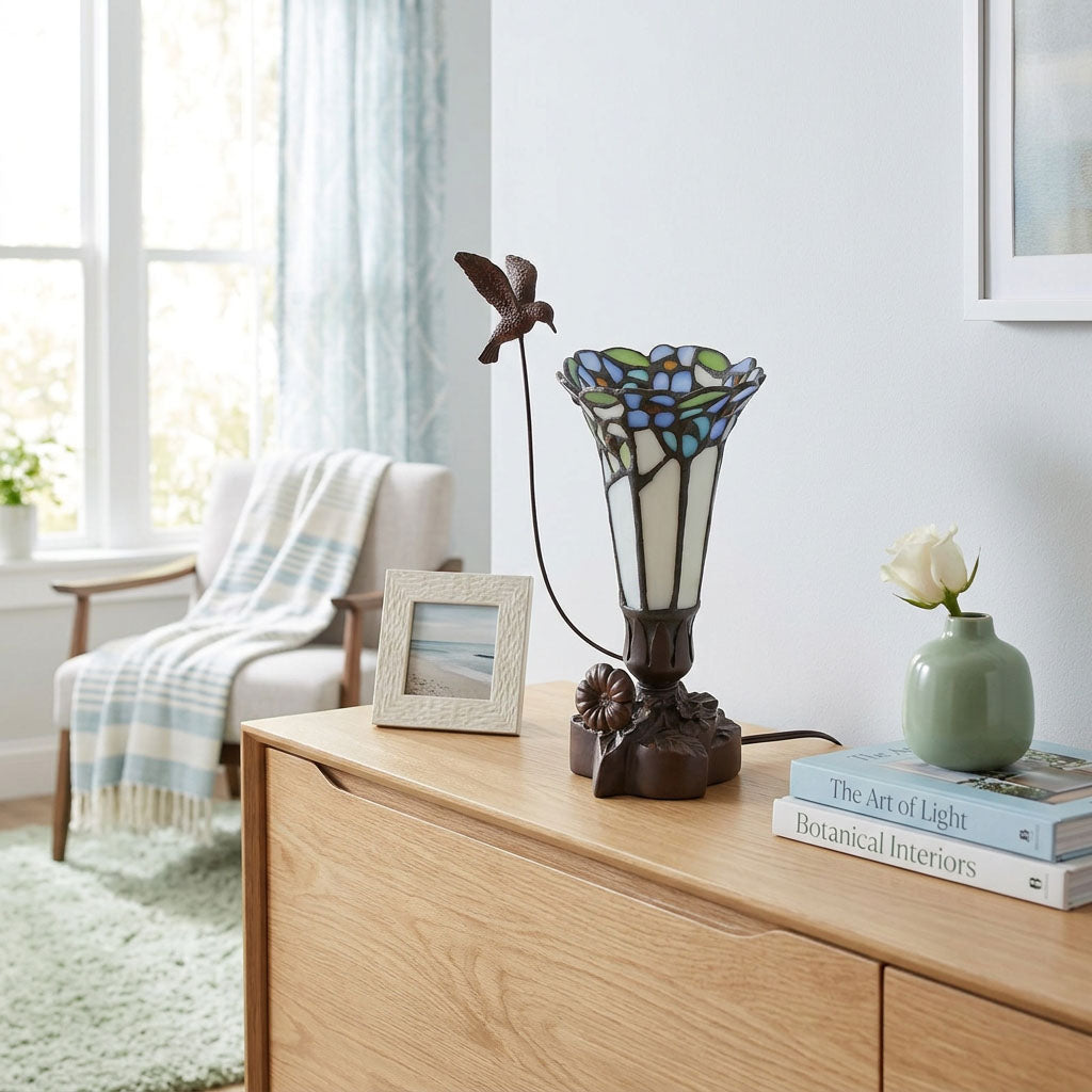 Tiffany styled cremation keepsake lamp that resembles a hummingbird feeding from a flower, with white and blue tones and resin base.