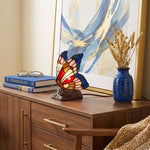 Stained glass and resin butterfly cremation keepsake and memory lamp in a home decor setting.