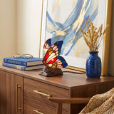 Stained glass and resin butterfly cremation keepsake and memory lamp in a home decor setting.