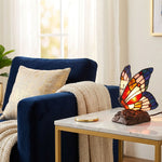 Stained glass and resin butterfly cremation keepsake and memory lamp on an end table.