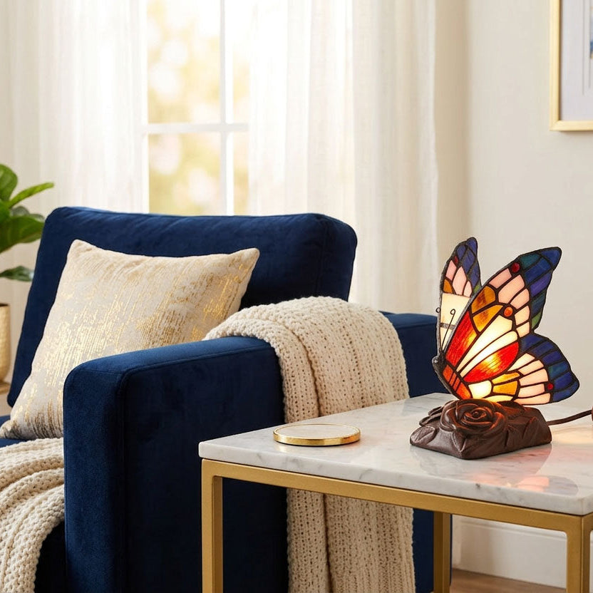 Stained glass and resin butterfly cremation keepsake and memory lamp on an end table.