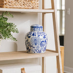 Large ceramic cremation urn for ashes with blue flowers sitting next on shelf, for perfect memorials to honor your loved one