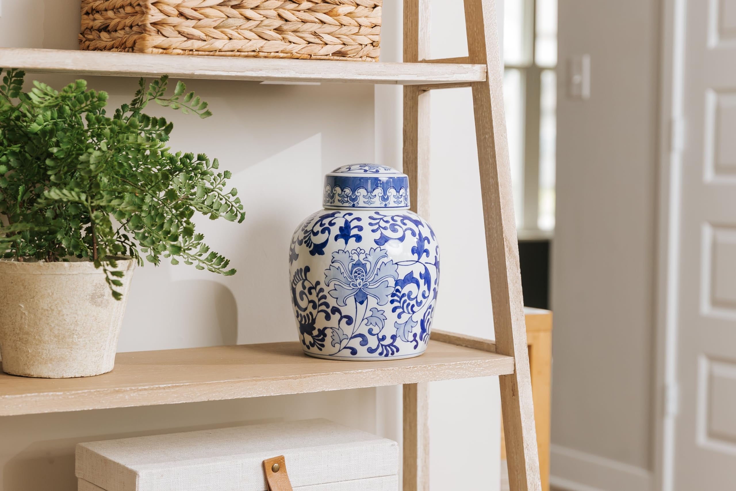 Large ceramic ginger jar cremation urn for ashes with a lovely chinoiserie pattern of blue flowers sitting next on shelf, for perfect memorials to honor your loved one