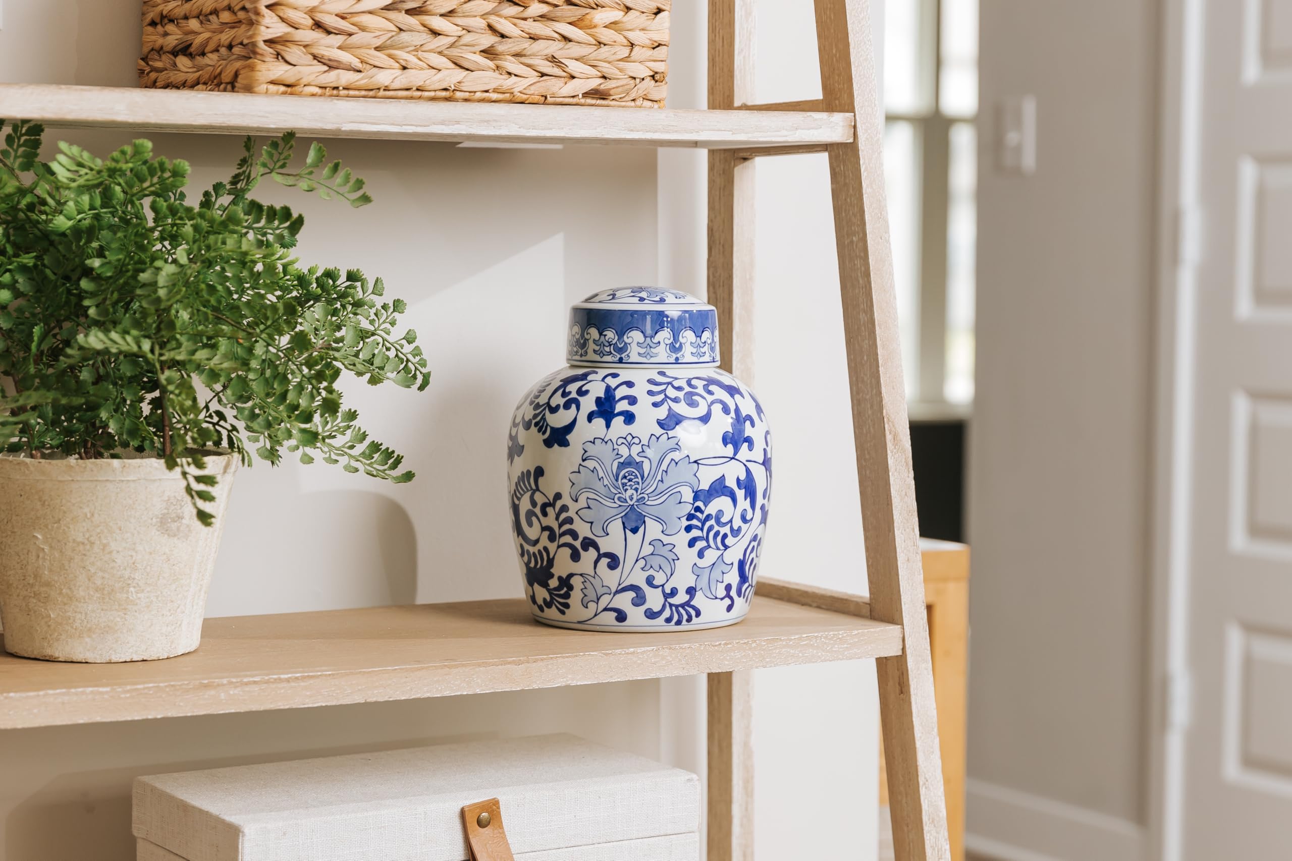 Large ceramic ginger jar cremation urn for ashes with a lovely chinoiserie pattern of blue flowers sitting next on shelf, for perfect memorials to honor your loved one
