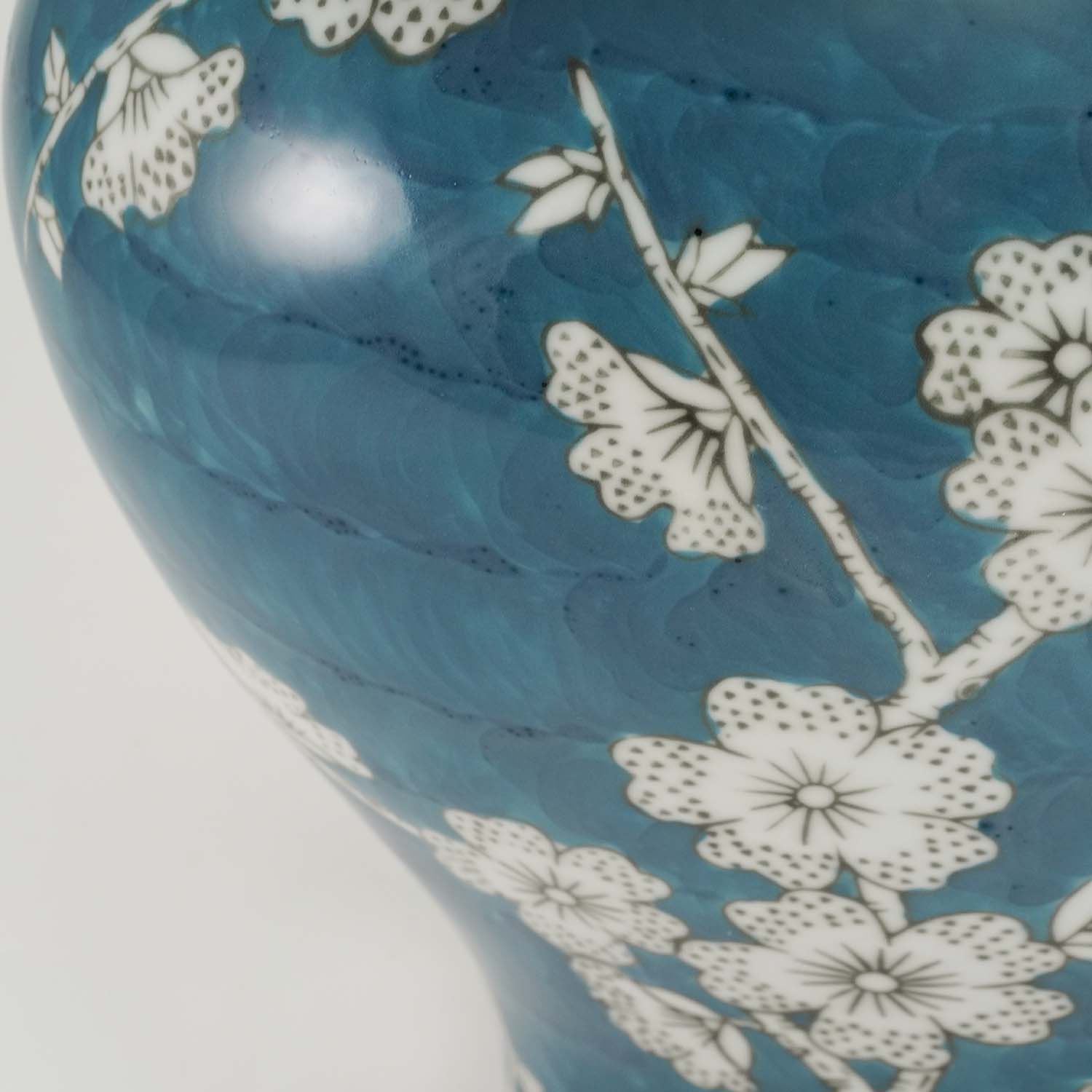 A blue ceramic urn featuring a delicate plum blossom design detail image.