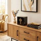 Natural black marble cremation urn with hand crafted gold celtic cross and pink shell inlay in a home decor setting.
