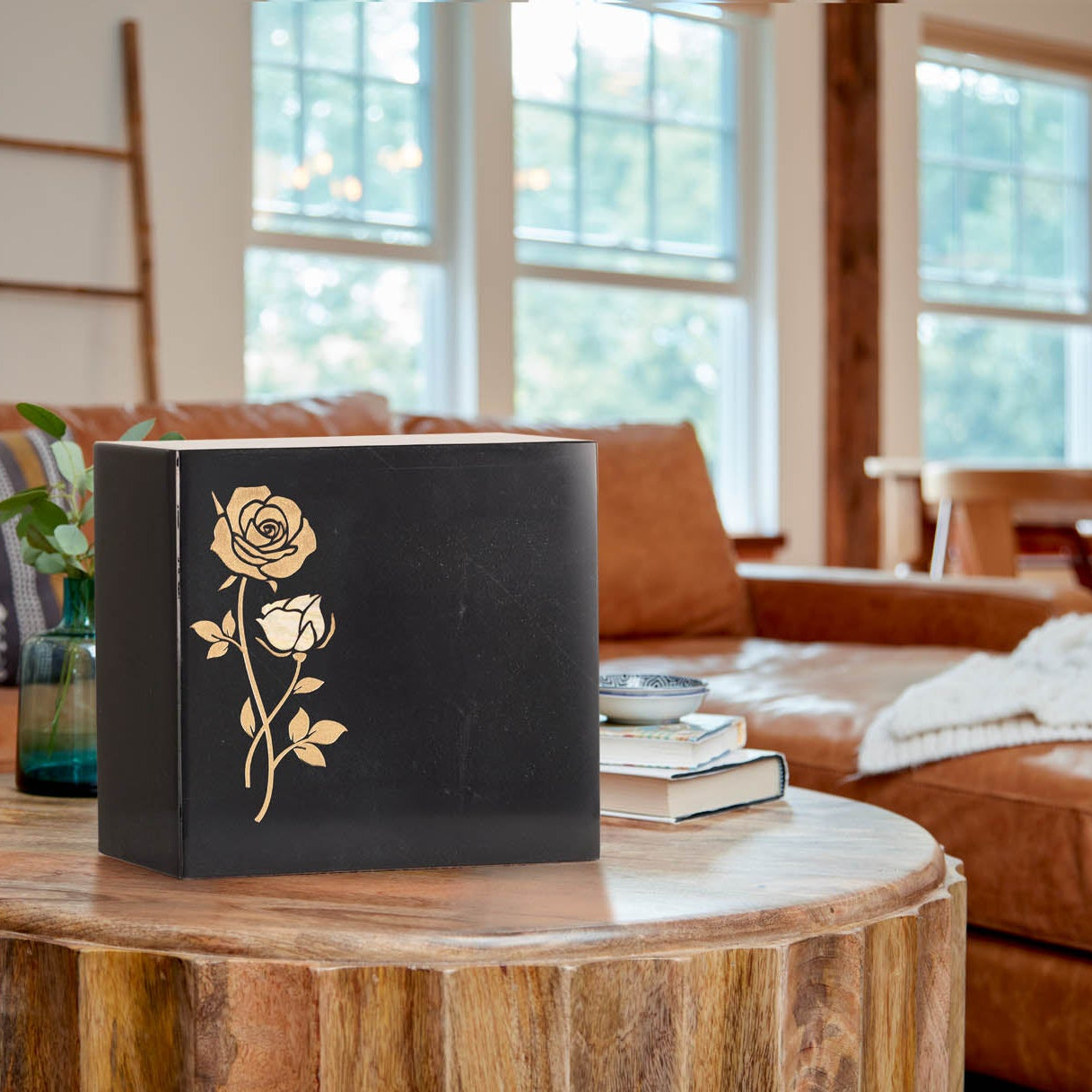 Natural black marble memorial urn featuring handcrafted gold rose designs with white shell inlay lifestyle.