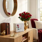 Natural white marble cremation urn with hand crafted red roses in a home decor setting.