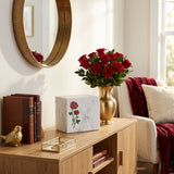 Natural white marble cremation urn with hand crafted red roses in a home decor setting.
