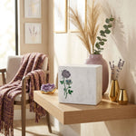Natural white marble urn with handcrafted rose design and blue shell inlay in a home decor setting.