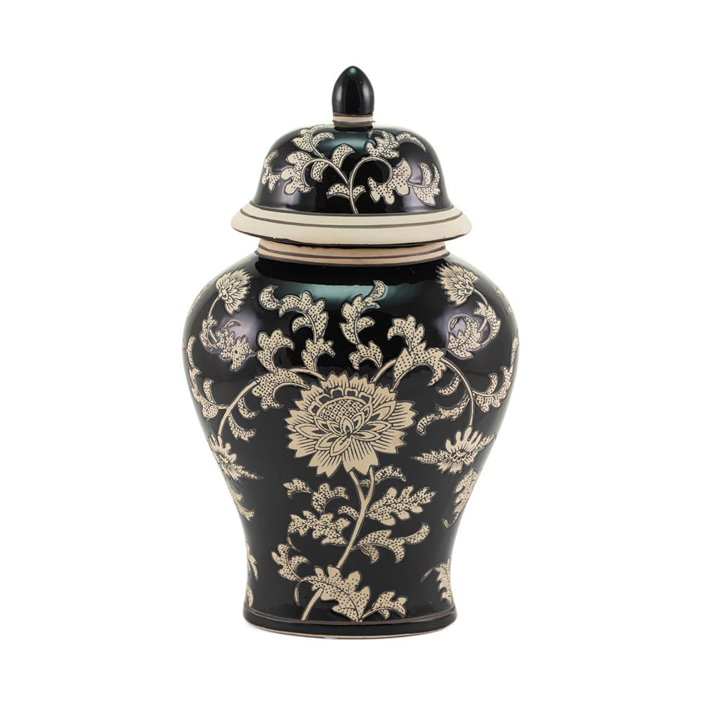 A black ceramic lidded urn in ginger jar style with a cream floral chinoiserie pattern, photographed against a solid white background.