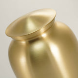 Golden metal cremation urn detail image.