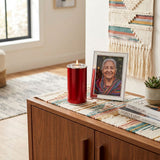 Keepsake for ashes with memory tealight candle in a scarlet red finish with pewter accents in a home decor setting.