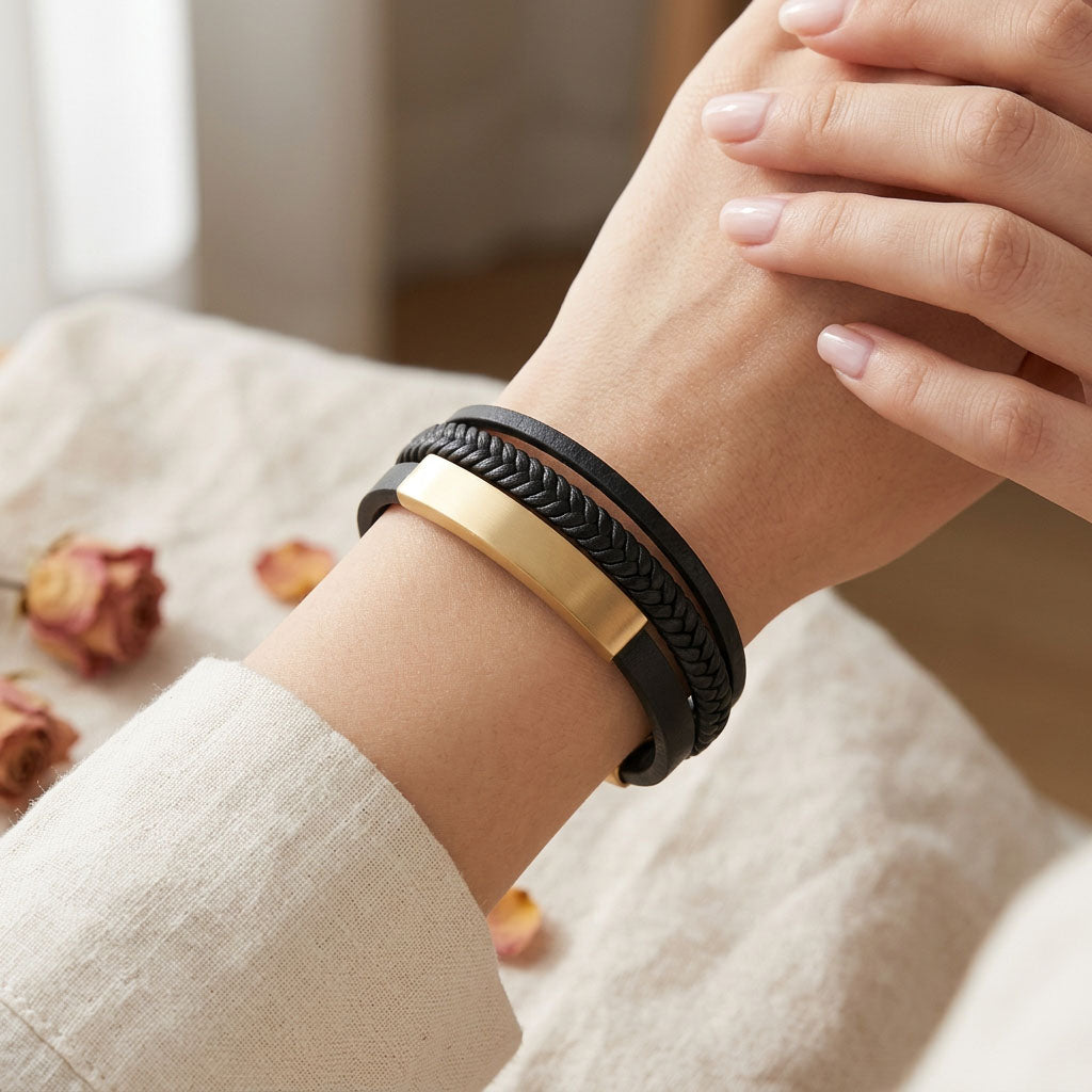 Black braided leather bracelet with gold accents close up.