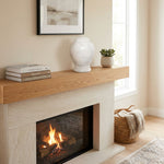 Natural white marble urn featuring two hand-carved rings in a home decor setting above a fireplace.