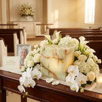 Cream & green natural marble urn with unique brown veining in a funeral service setting.