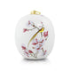 White ceramic bird urn with pink floral scene and gold-tone lid handle