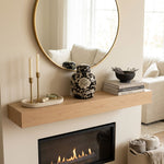 Black floral ceramic urn featuring a lotus design in a home decor setting on a mantle above a fireplace